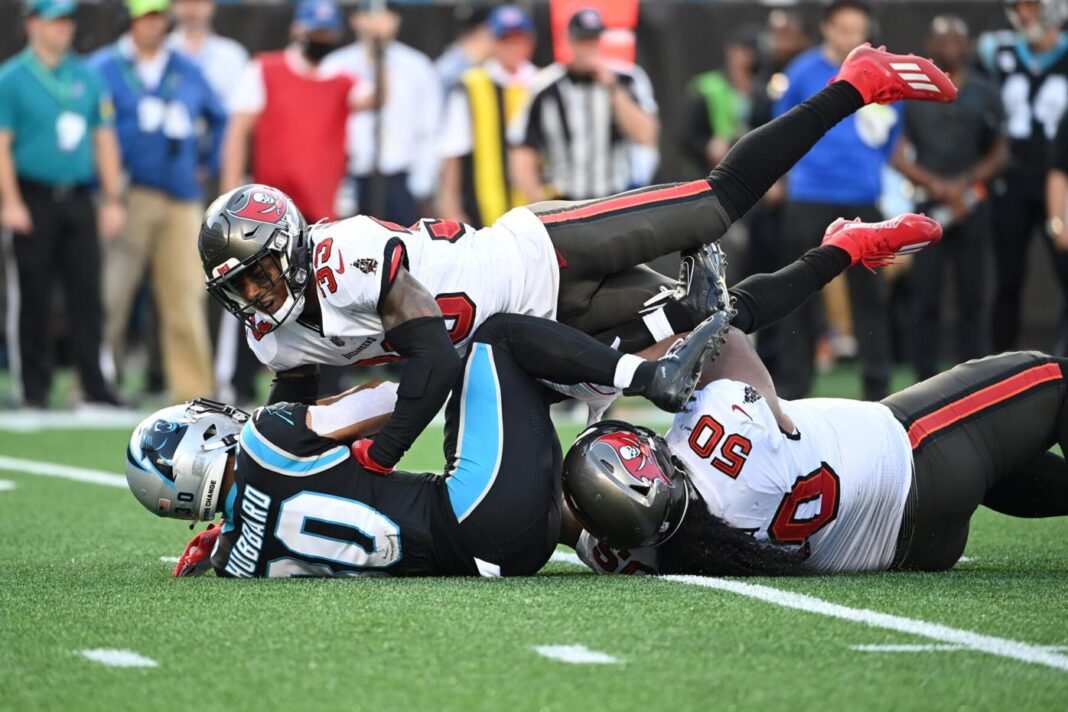 Panthers running back Chuba Hubbard (30) is tackled by Tampa Bay Buccaneers nose tackle Vita Vea (50) and free safety Jordan Whitehead (33) in the third quarter at Bank of America Stadium. Mandatory Credit: Bob Donnan-USA TODAY Sports