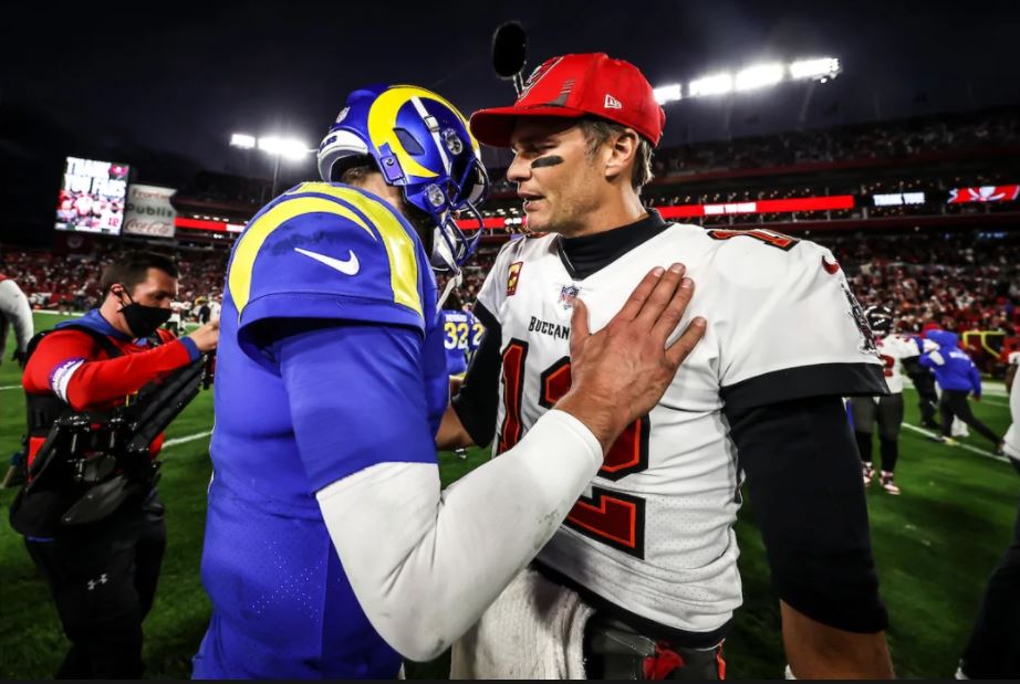 Buccaneers QB Tom Brady shares a moment with a Rams player after the Divisional Playoff game. Via Buccaneers.com