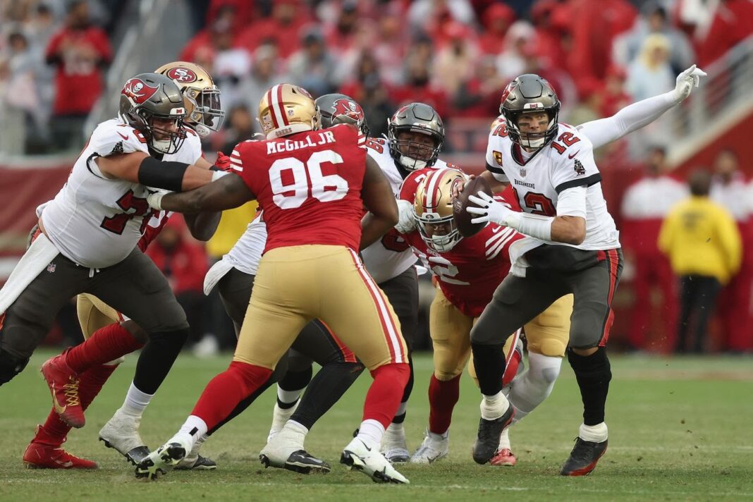 Buccaneers' quarterback Tom Brady escapes pressure from the 49ers' defense / via Getty Images