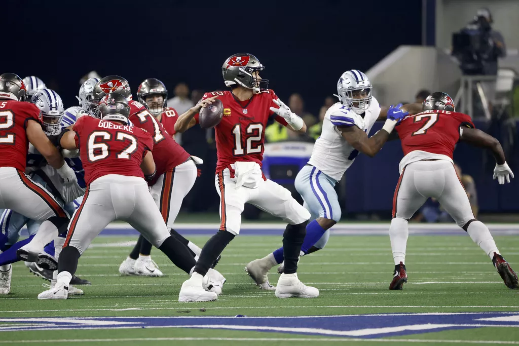 Tampa Bay Buccaneers quarterback Tom Brady (12) prepares to throw a pass as running back Leonard Fournette (7) helps against pressure from Dallas Cowboys linebacker Micah Parsons, second from right, in the second half of a NFL football game in Arlington, Texas, Sunday, Sept. 11, 2022. (AP Photo/Ron Jenkins)(Ron Jenkins / Associated Press)